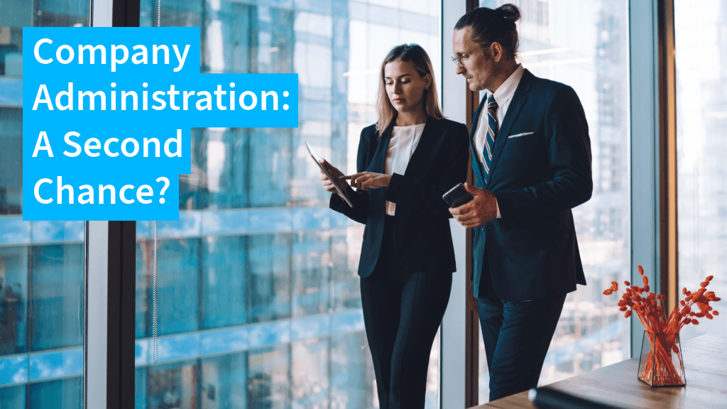 Two business people in an office looking at documents, with "Company Administration: A Second Chance?" overlaid as text